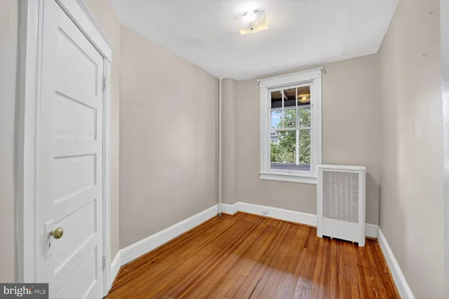 a view of a room with wooden floor and window