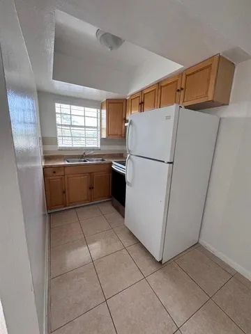 a kitchen with granite countertop a refrigerator and a sink