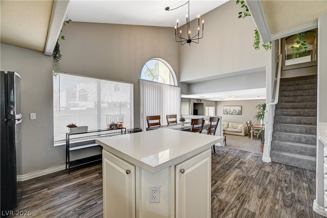 8863 Chapman Point Las Vegas, NV 89129 - Photo 22 of 22 Kitchen featuring a kitchen island, freestanding refrigerator, white cabinetry, open floor plan, and light stone countertops