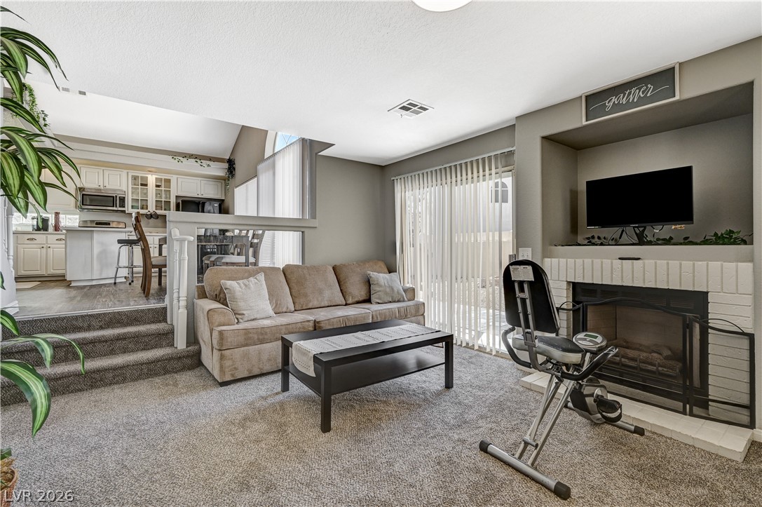 8863 Chapman Point Las Vegas, NV 89129 - Photo 15 of 22 Carpeted living area featuring a fireplace and a textured ceiling