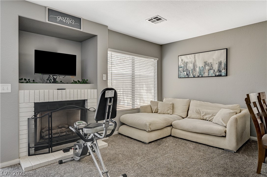 8863 Chapman Point Las Vegas, NV 89129 - Photo 18 of 22 Living area with carpet and a brick fireplace