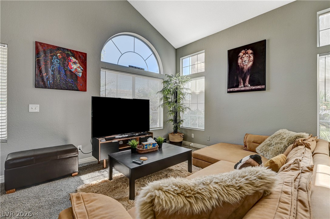 8863 Chapman Point Las Vegas, NV 89129 - Photo 2 of 22 Living area featuring lofted ceiling and carpet floors