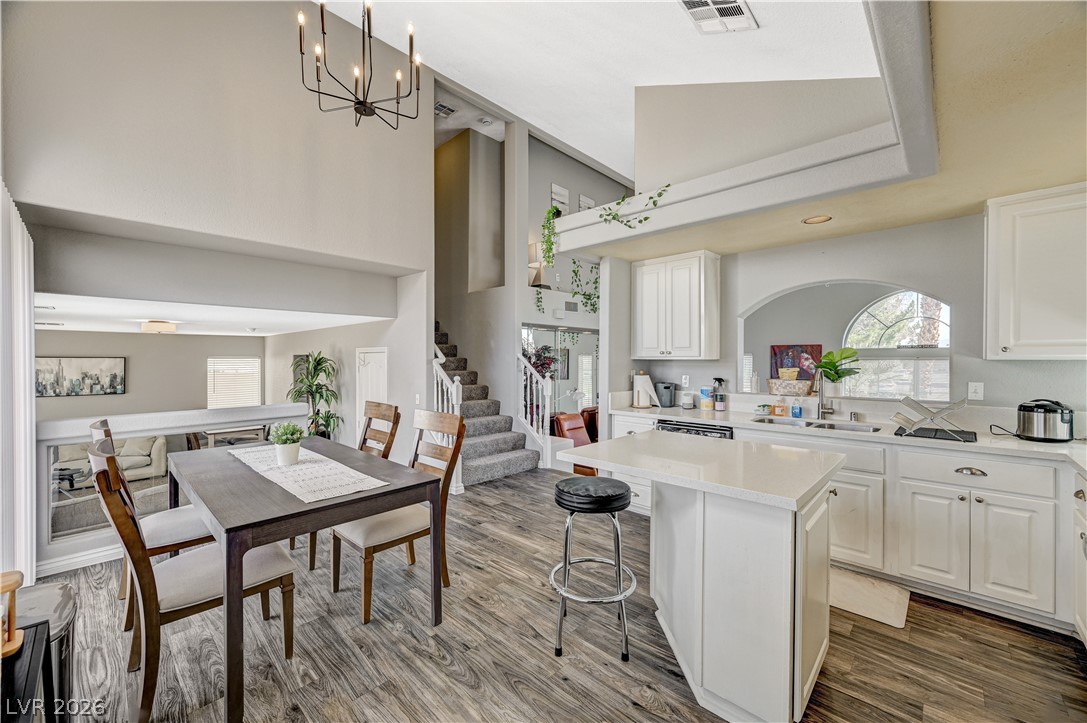 8863 Chapman Point Las Vegas, NV 89129 - Photo 21 of 22 Kitchen with white cabinets, open floor plan, and a kitchen bar