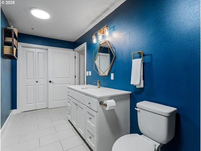 a spacious bathroom with a toilet a sink and mirror