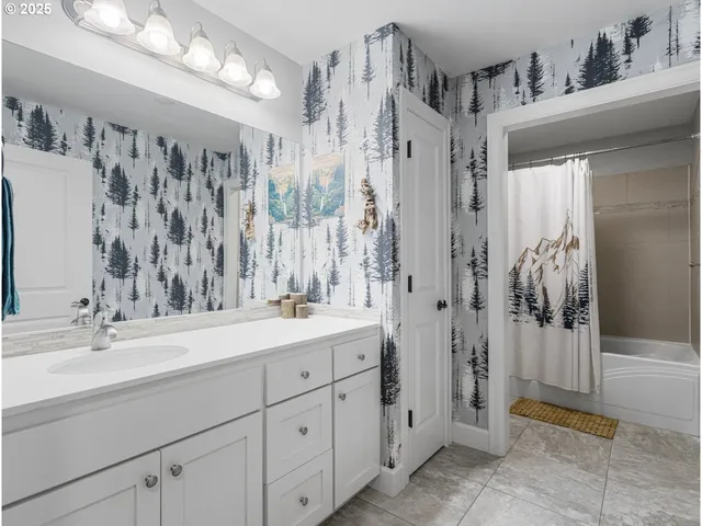 a bathroom with a double vanity sink mirror and shower