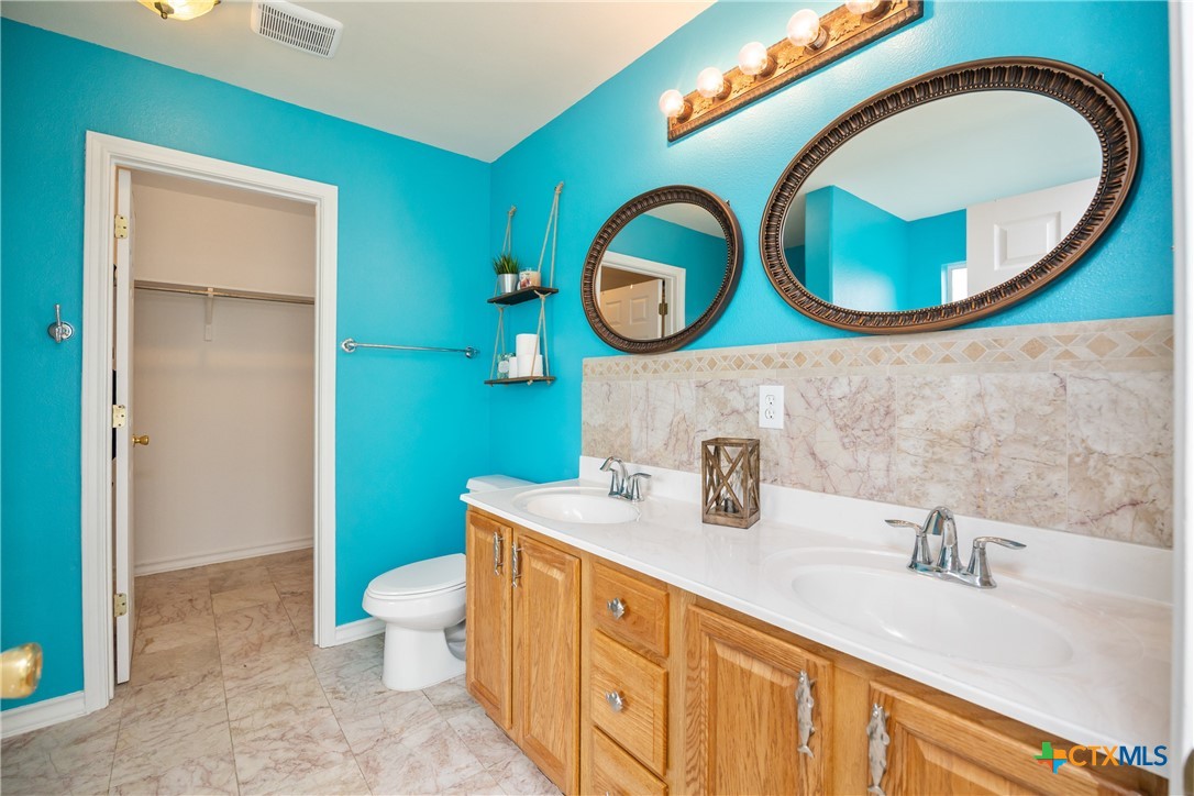 118 South Walker Road Aransas Pass, TX 78336 - Photo 15 of 20 a bathroom with a toilet a sink and a mirror
