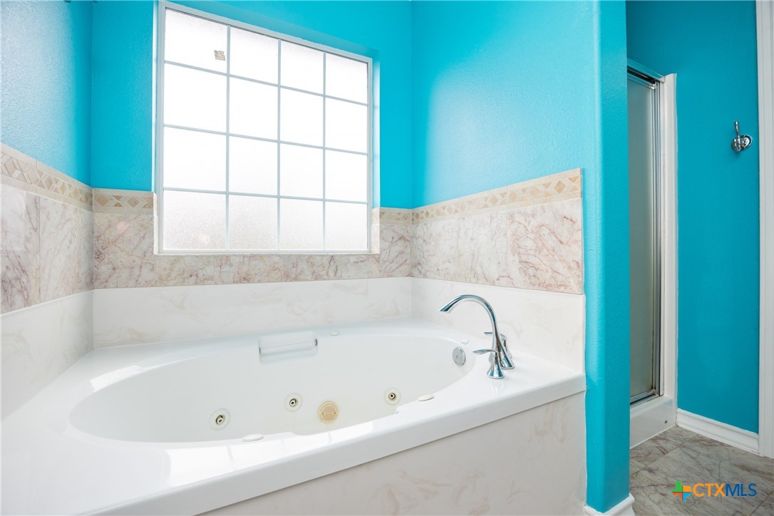 118 South Walker Road Aransas Pass, TX 78336 - Photo 16 of 20 a bathroom with a bathtub and window