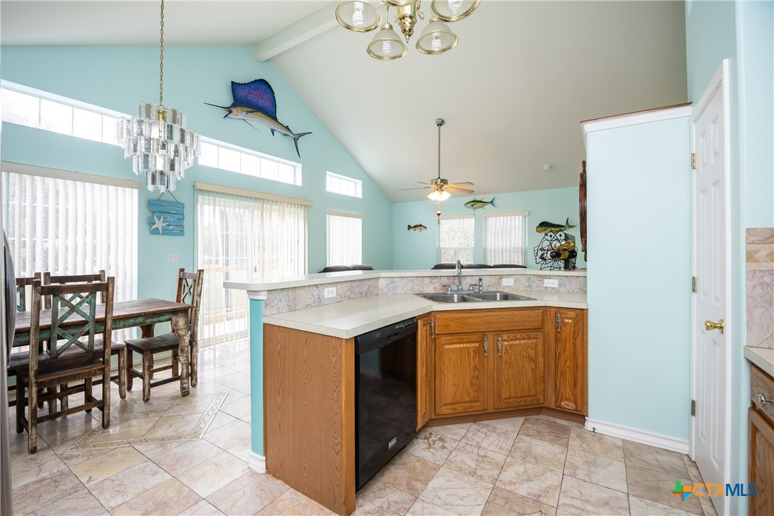 118 South Walker Road Aransas Pass, TX 78336 - Photo 7 of 20 a kitchen with kitchen island granite countertop dining table chairs sink and cabinets