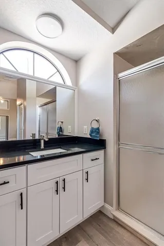 a bathroom with a granite countertop sink and a mirror