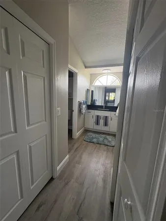 a view of a hallway with wooden floor fireplace and staircase