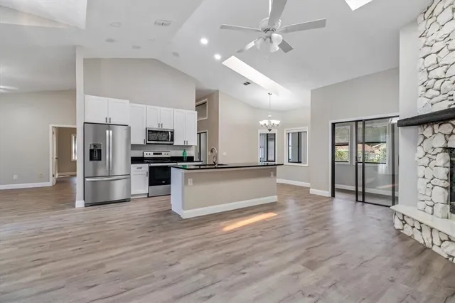 an open kitchen with white cabinets and stainless steel appliances