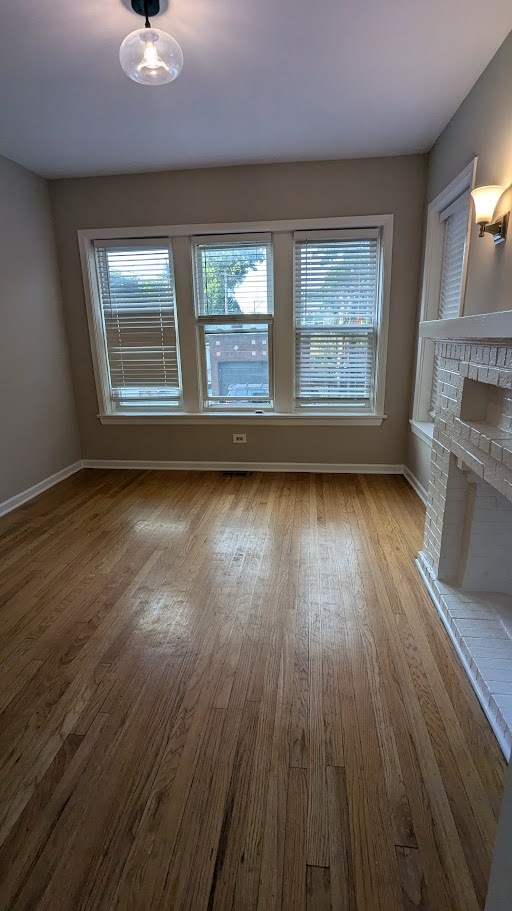 3745 West Argyle Street, Unit 1 Chicago, IL 60625 - Photo 11 of 35 an empty room with wooden floor and windows