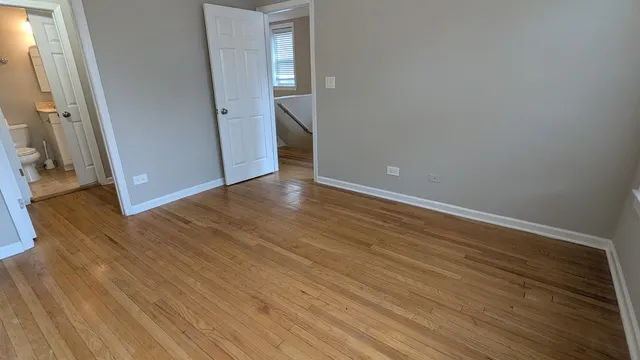 an empty room with wooden floor and entrance