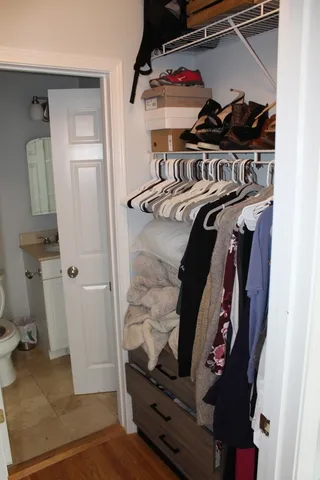 a view of walk in closet with clothes and shoes