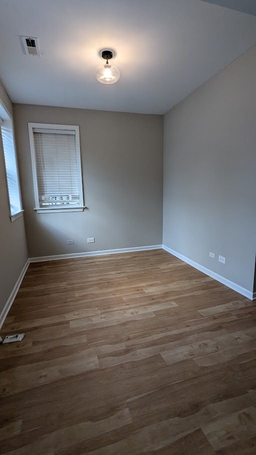 3745 West Argyle Street, Unit 1 Chicago, IL 60625 - Photo 25 of 35 an empty room with wooden floor and windows