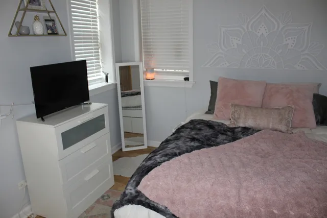 a bedroom with a bed and flat screen tv