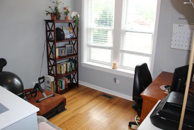 a view of a workspace with furniture and a window