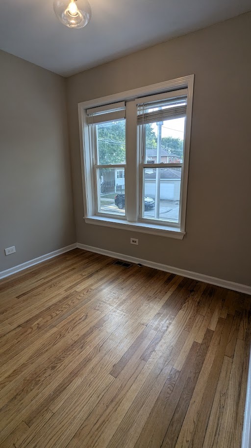 3745 West Argyle Street, Unit 1 Chicago, IL 60625 - Photo 9 of 35 a view of an empty room with wooden floor and a window
