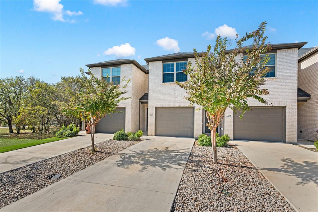 1218 Chestnut Court, Unit 2 Runaway Bay, TX 76426 - Photo 2 of 26 a front view of a house with a yard and garage