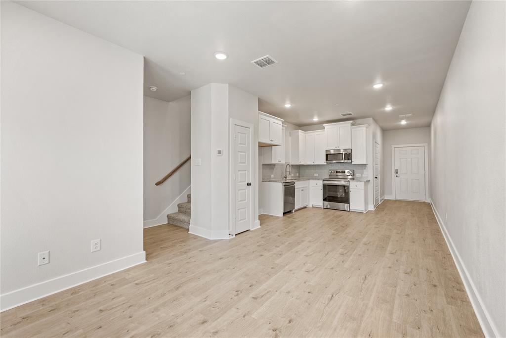 1218 Chestnut Court, Unit 2 Runaway Bay, TX 76426 - Photo 5 of 26 a view of kitchen with refrigerator stove microwave and cabinets