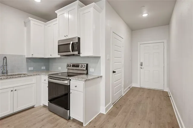 a kitchen with stainless steel appliances granite countertop a stove and a sink