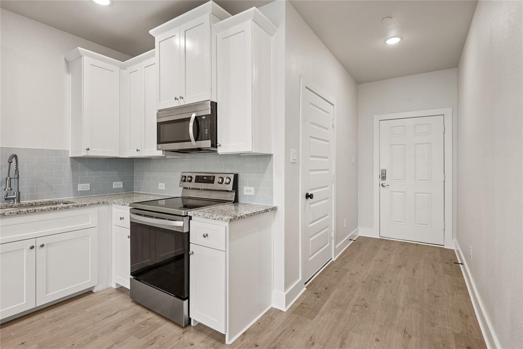 1218 Chestnut Court, Unit 2 Runaway Bay, TX 76426 - Photo 8 of 26 a kitchen with stainless steel appliances granite countertop a stove and a sink