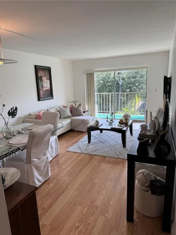 a living room with furniture large window and flat screen tv