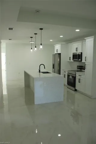a large kitchen with kitchen island a sink stainless steel appliances and cabinets