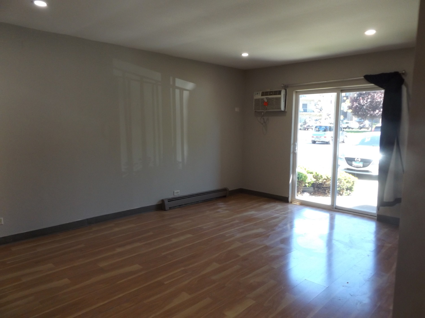 710 West Huntington Commons Road, Unit 1A Mount Prospect, IL 60056 - Photo 10 of 10 a view of an empty room with wooden floor and a window