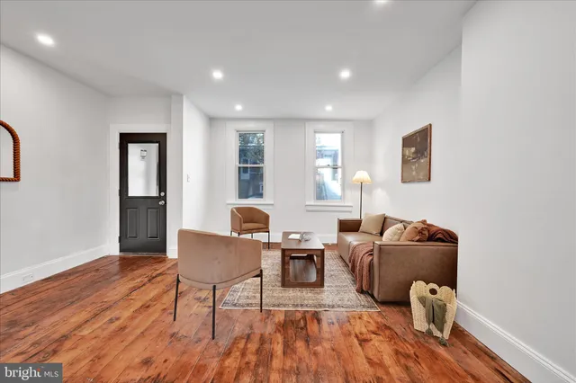 a living room with furniture and wooden floor