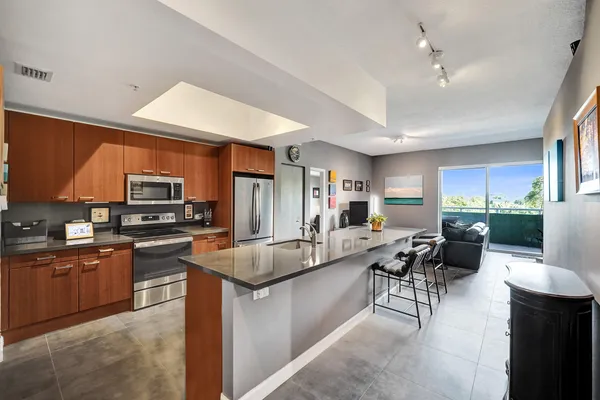 a large kitchen with stainless steel appliances granite countertop a lot of counter space and a sink