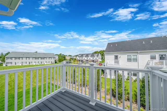 a view of a balcony with wooden floor and fence