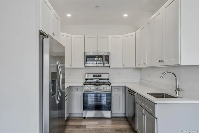 a kitchen with cabinets stainless steel appliances and a sink