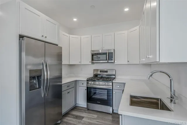 a kitchen with stainless steel appliances granite countertop a stove a refrigerator and a sink