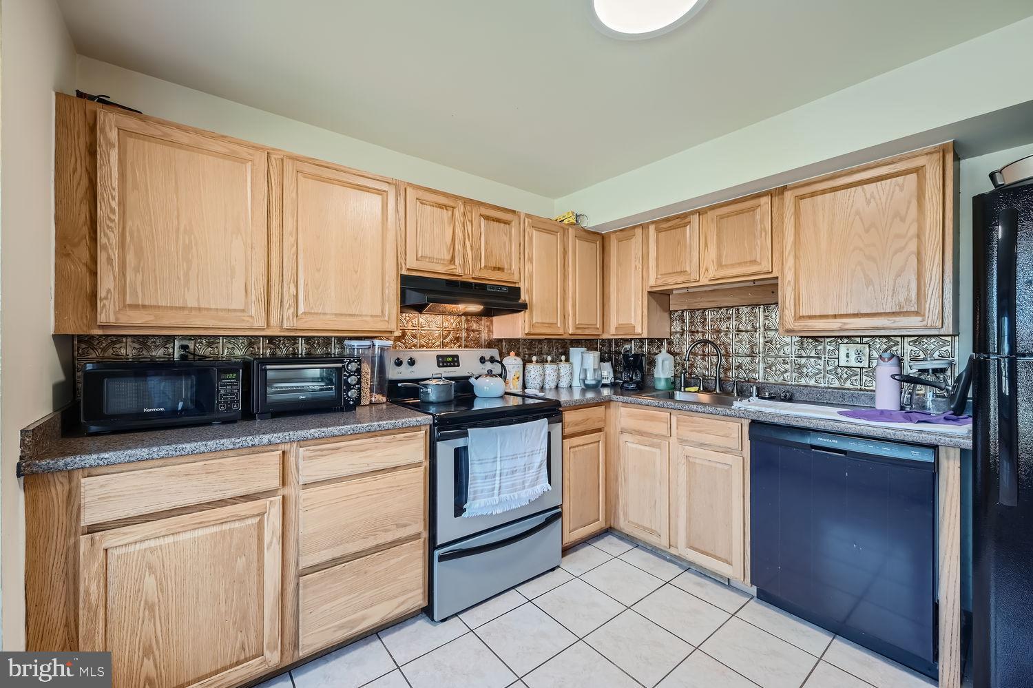 5435 King Arthur Circle Rosedale, MD 21237 - Photo 14 of 28 Modern kitchen with warm wood cabinetry.