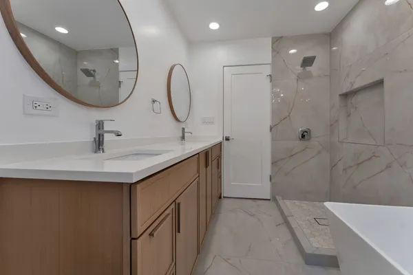 a bathroom with a sink a toilet a shower and mirror