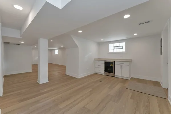 an empty room with wooden floor and fireplace