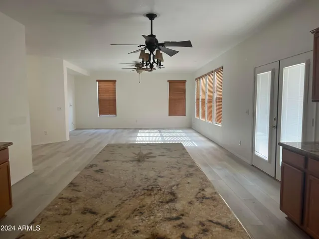a view of hallway with wooden floor and chandelier