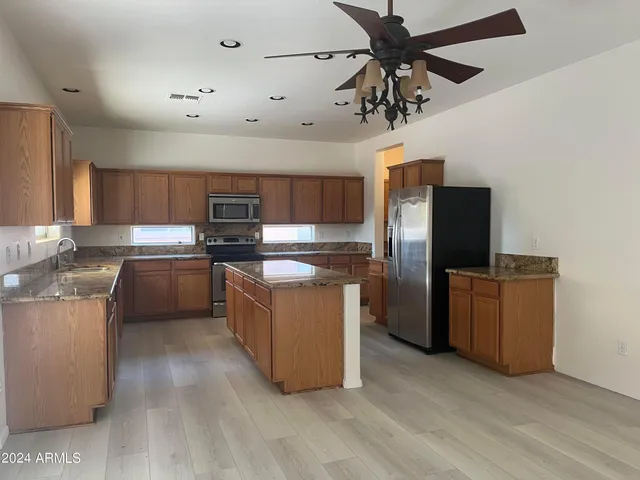 a kitchen with stainless steel appliances granite countertop a refrigerator a stove top oven a sink and dishwasher