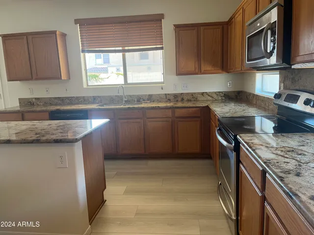 a kitchen with stainless steel appliances granite countertop a sink stove and microwave