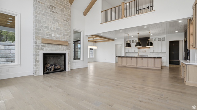1682 North 1950 W Street, Unit 9 Provo, UT 84604 - Photo 16 of 84 Spacious living area featuring a stone fireplace, wood-finish flooring, and high ceilings with exposed beams