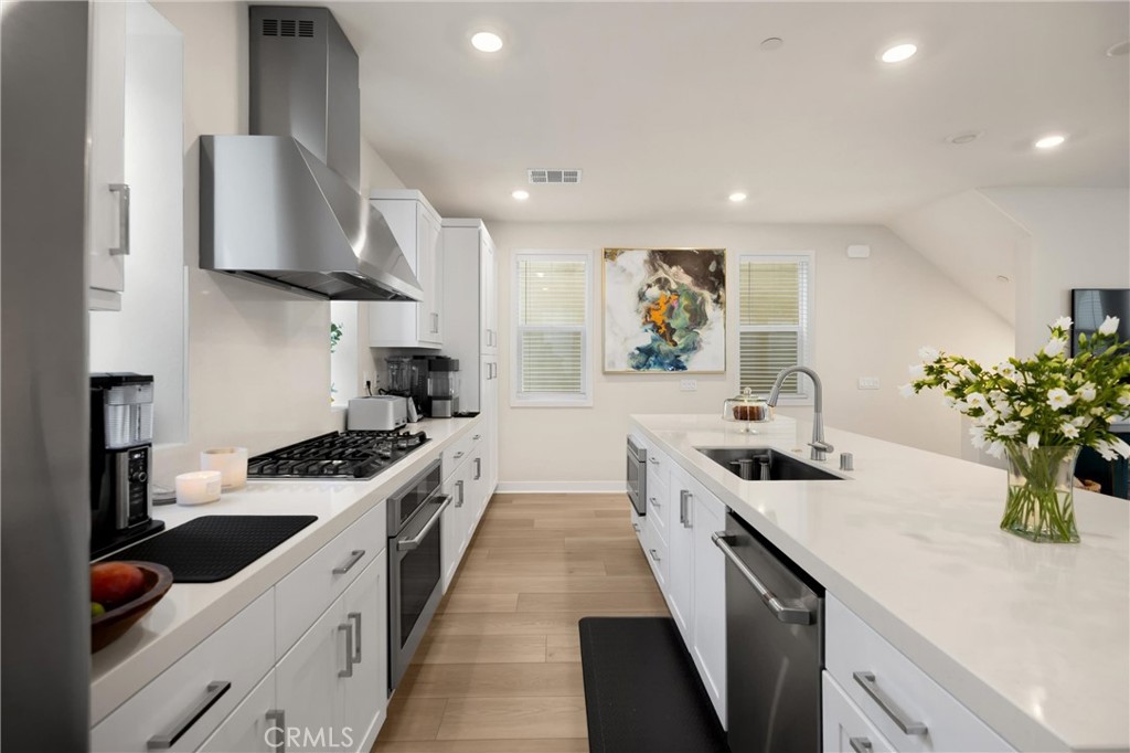 26 Crown Point Drive Rancho Mission Viejo, CA 92694 - Photo 9 of 42 a kitchen with stainless steel appliances a sink stove and cabinets