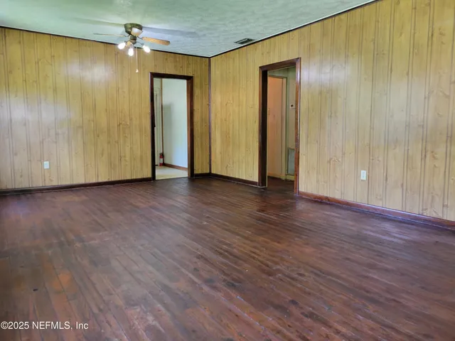 an empty room with wooden floor and closet
