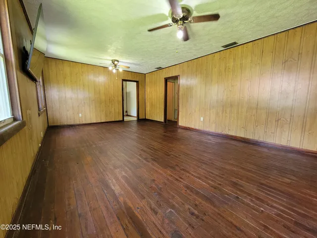 a view of an empty room with wooden floor