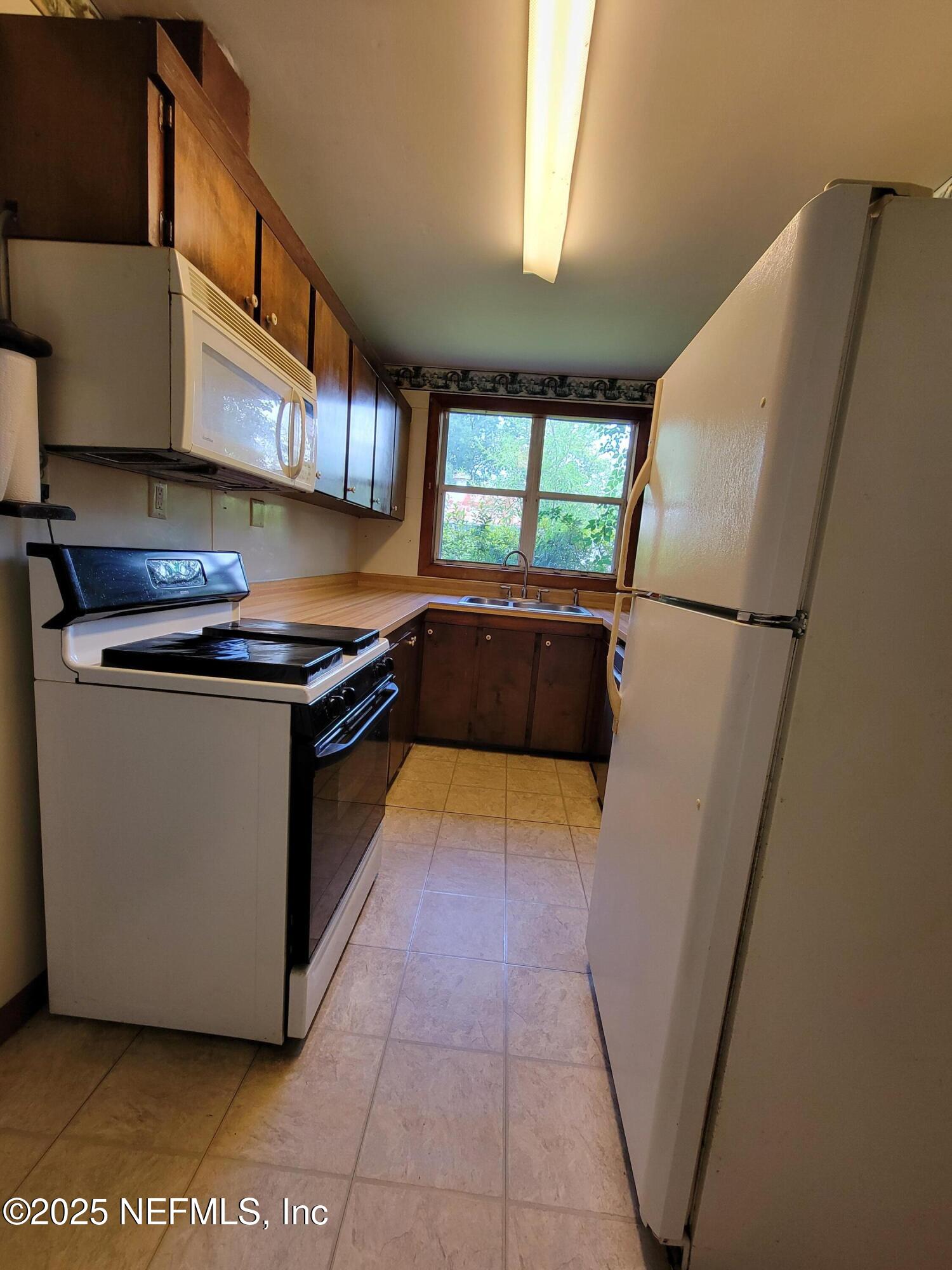 762 North Walnut Street Starke, FL 32091 - Photo 18 of 38 a kitchen with stainless steel appliances granite countertop a sink a stove a refrigerator a washer and dryer