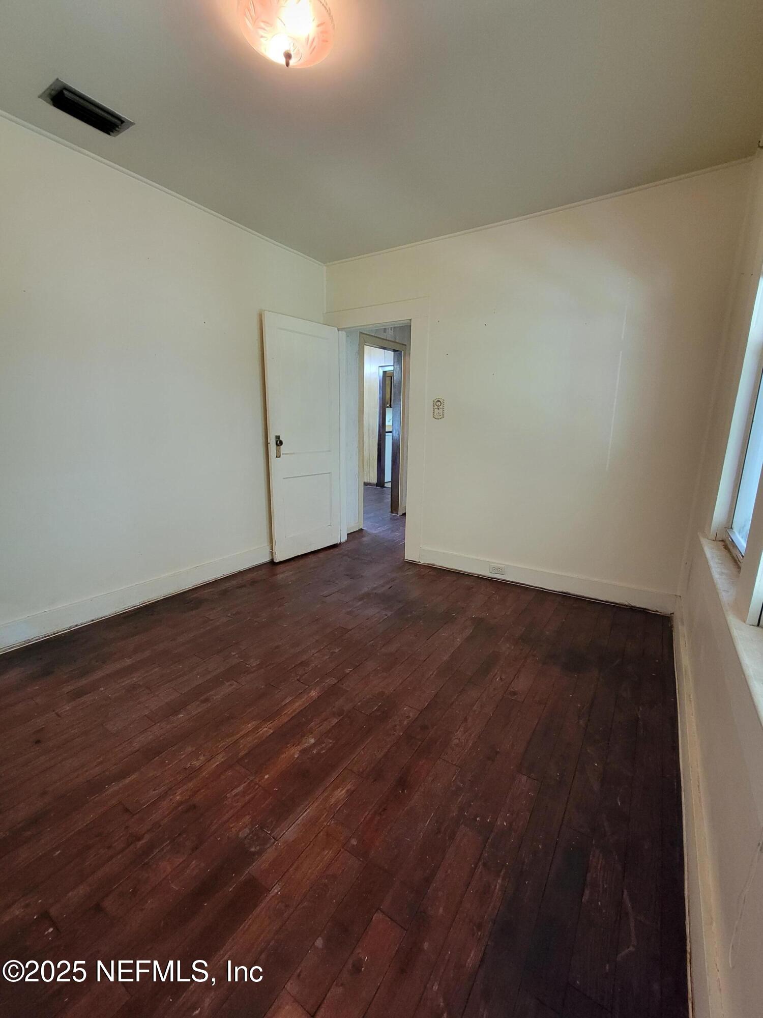 762 North Walnut Street Starke, FL 32091 - Photo 22 of 38 an empty room with wooden floor and windows