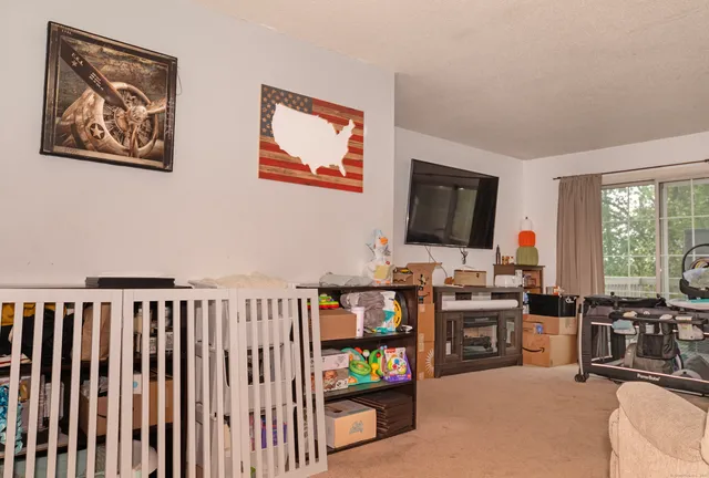 a living room with furniture a flat screen tv and a large window