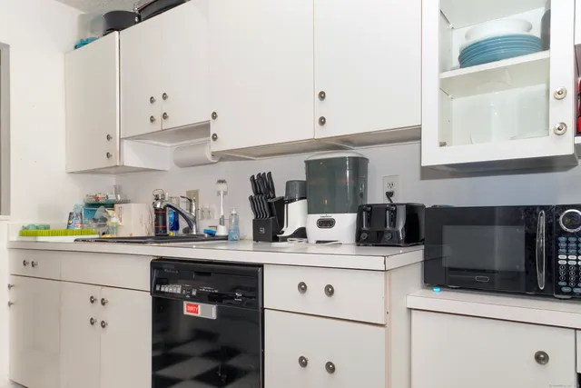 a kitchen with stainless steel appliances granite countertop a sink a stove and white cabinets