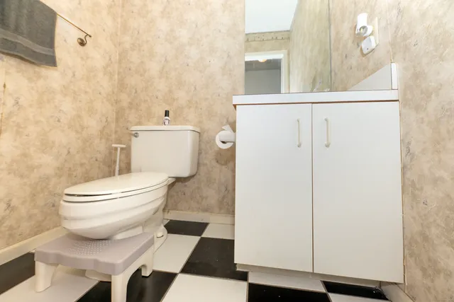a white toilet sitting next to a bathroom sink