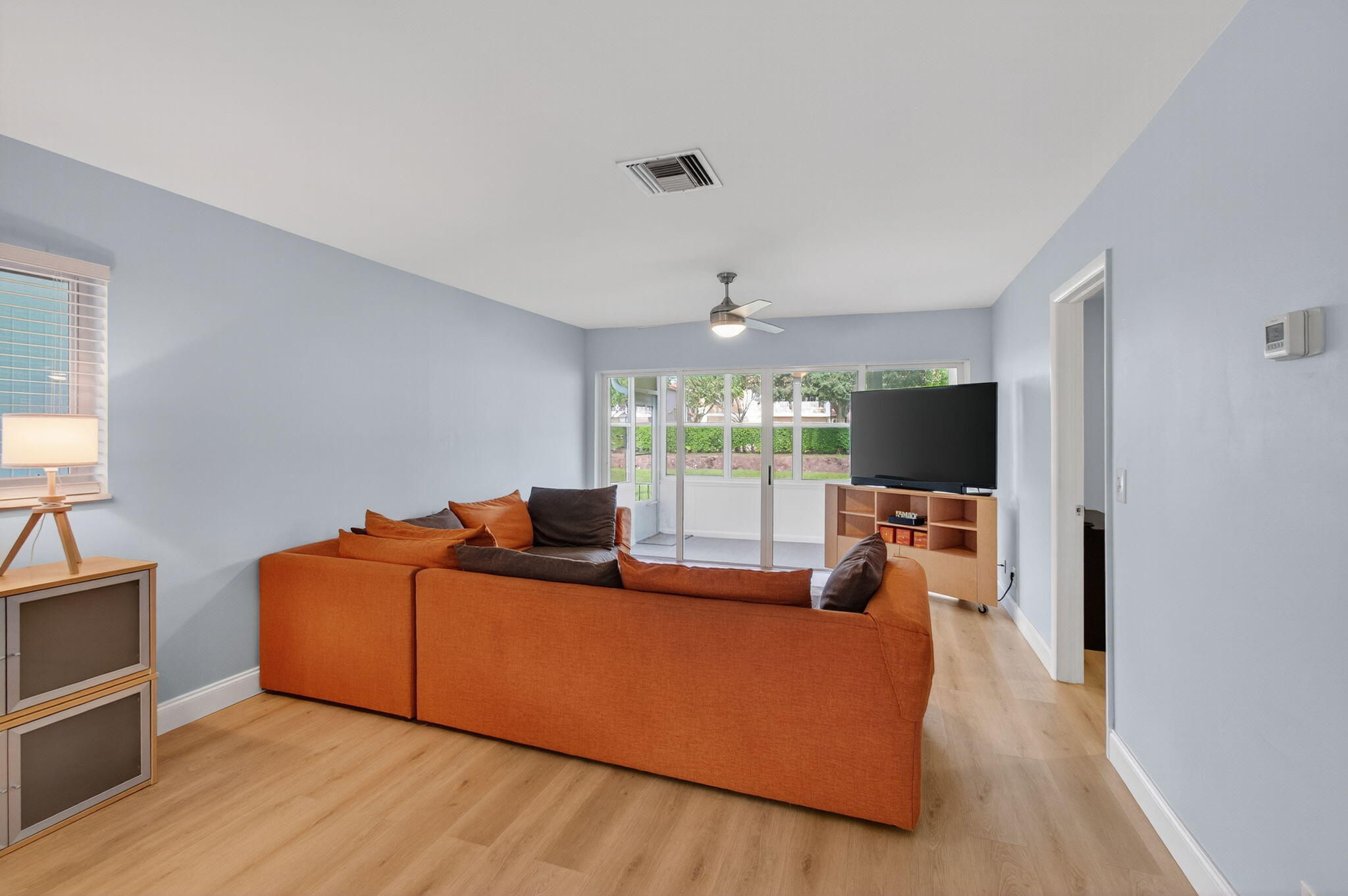 632 Hummingbird Lane Delray Beach, FL 33445 - Photo 11 of 60 a living room with furniture a flat screen tv and a large window